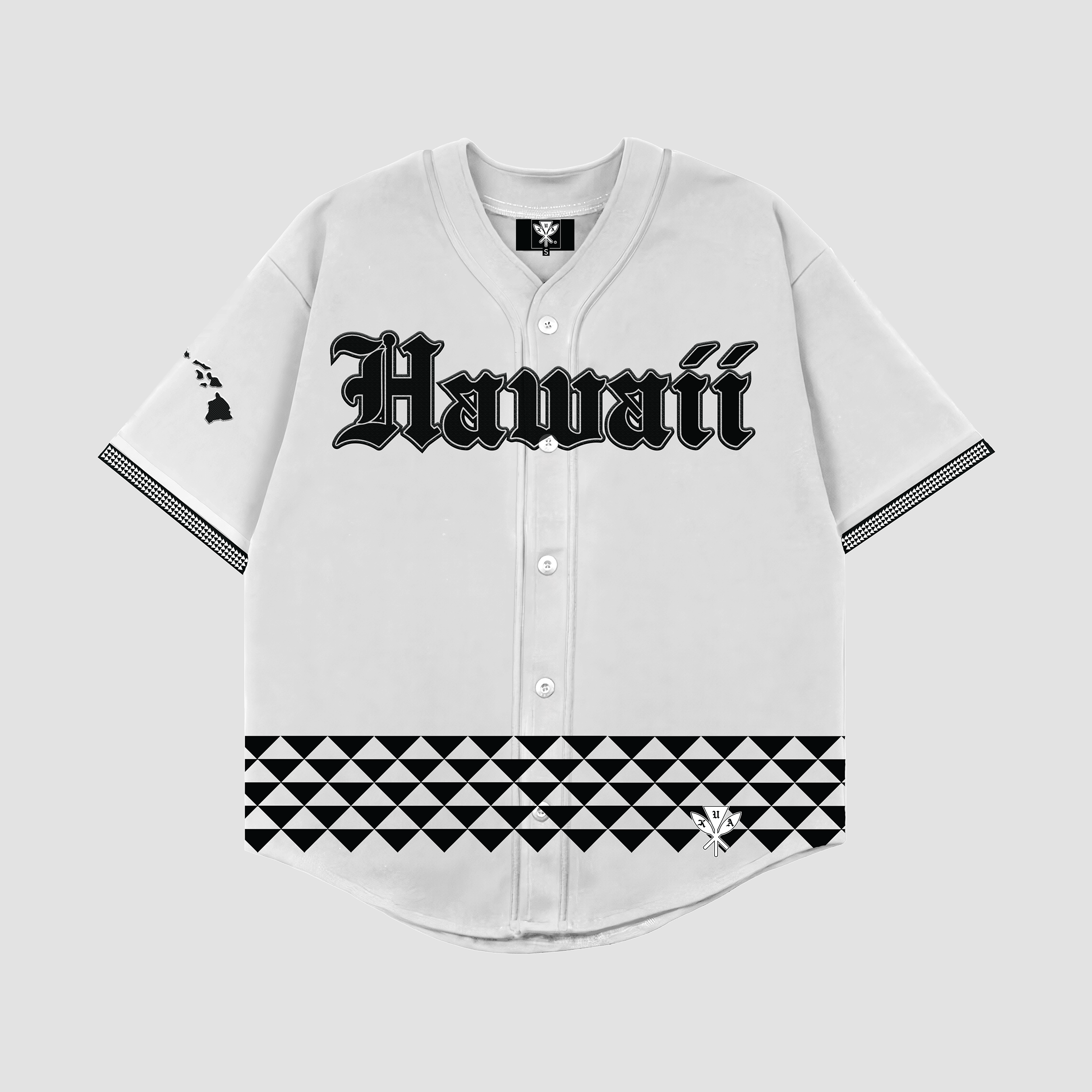 A white baseball jersey with 'Hawaii' written across the chest in bold old English lettering, featuring tribal patterns on the lower half and embroidered logos on the shoulders and sleeves.