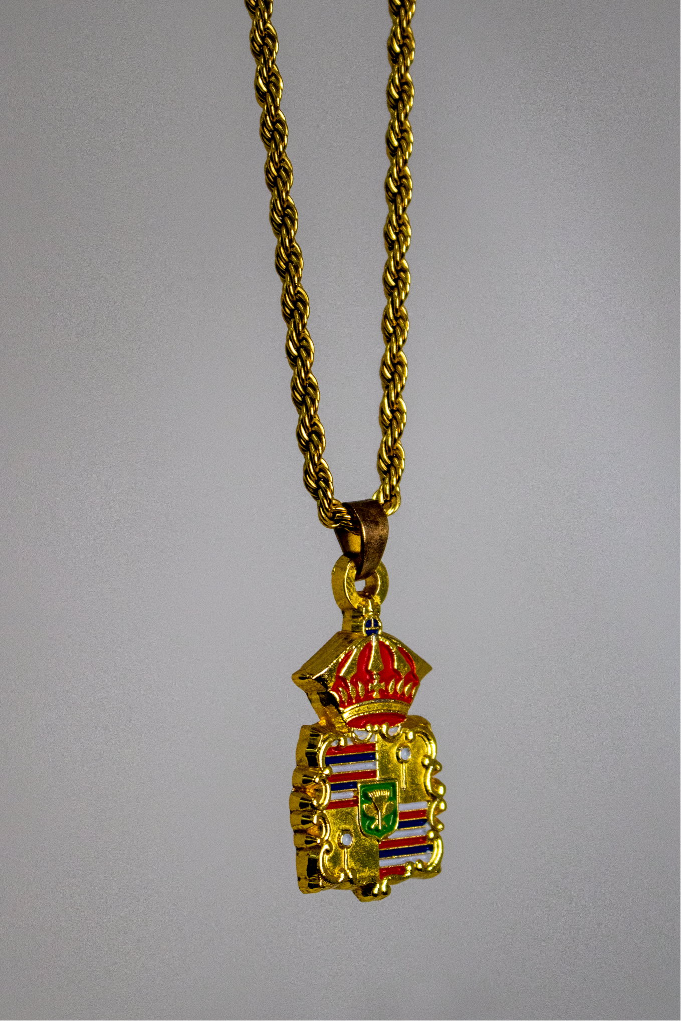 Introducing our Hawaiian Royal Crest pendant. Symbolizing power and heritage, our chain showcases intricate design elements from Hawaiian culture - kahili, spears, and the crown, mirroring the Hawaiian's rich royal history. Each chain wearer captures the authority and connection to the land, and royalty offering wearers a chance to embody the strength and prestige of Hawaiian monarchy. This symbol is important for our and all Hawaii clothing brands.